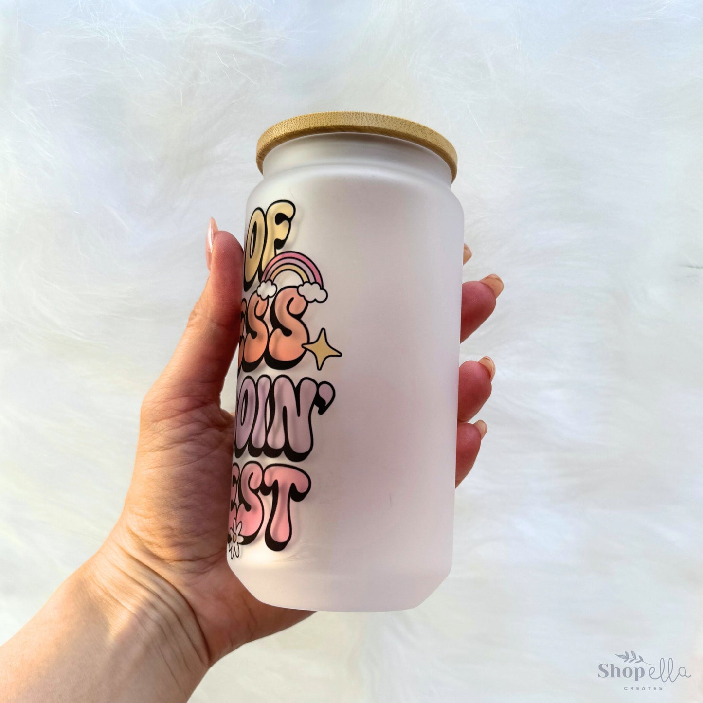 a hand holding a white can with graffiti on it