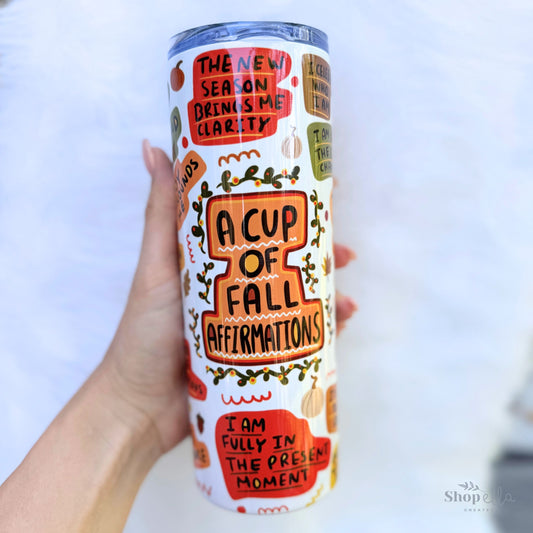 a hand holding a white 20oz skinny tumbler with lid a cup of fall affirmations