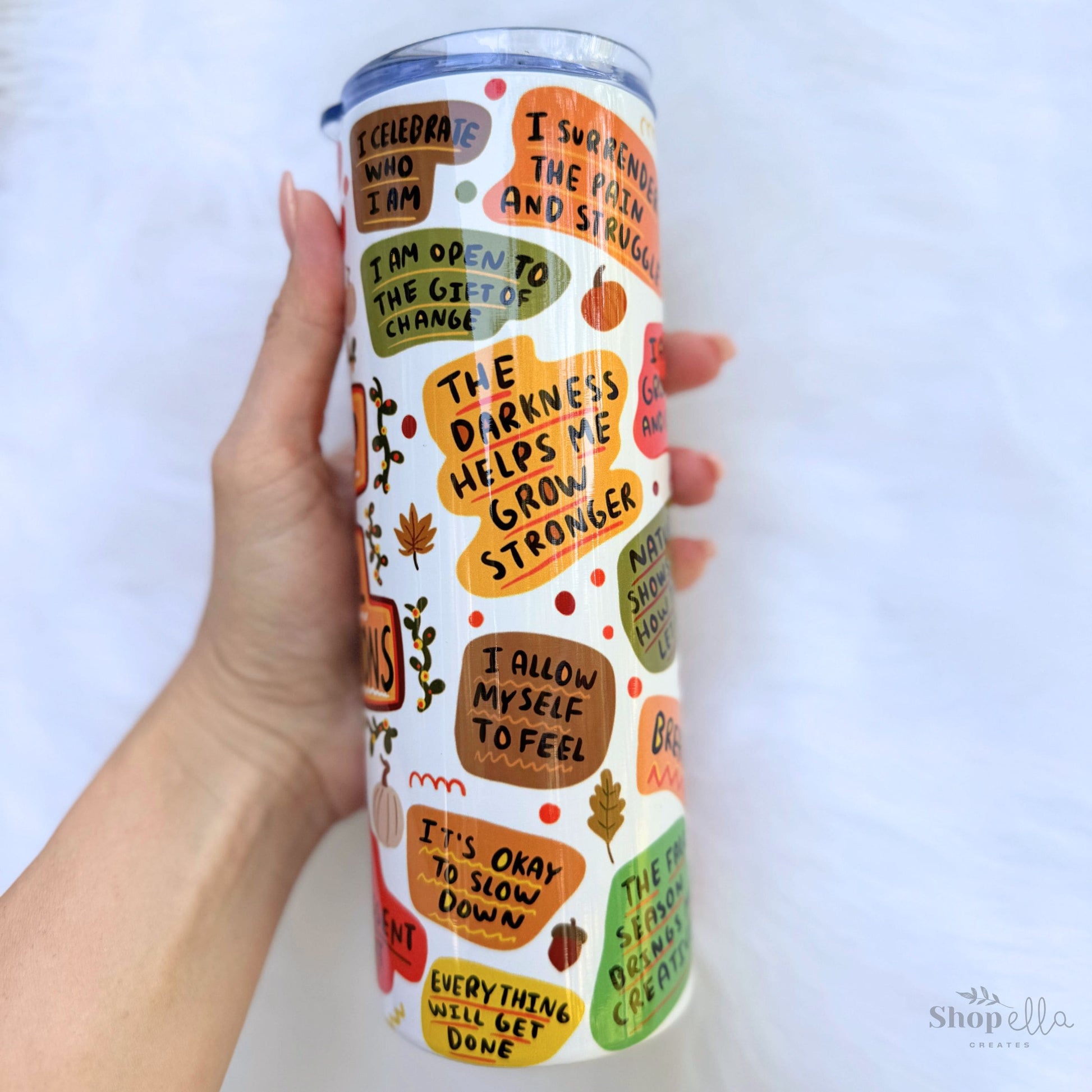 a hand holding a white 20oz skinny tumbler with lid a cup of fall affirmations