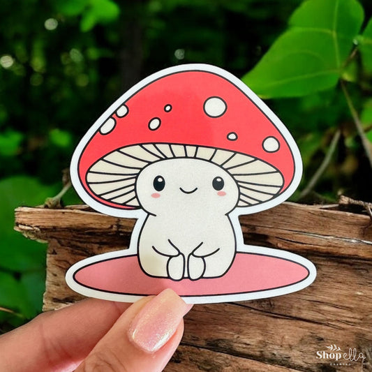 a hand holding a sticker with a mushroom on it