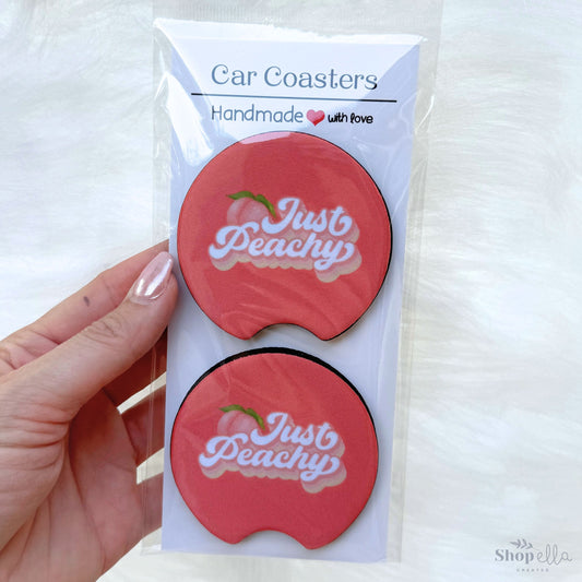 a hand holding a package of retro just peachy car coaster