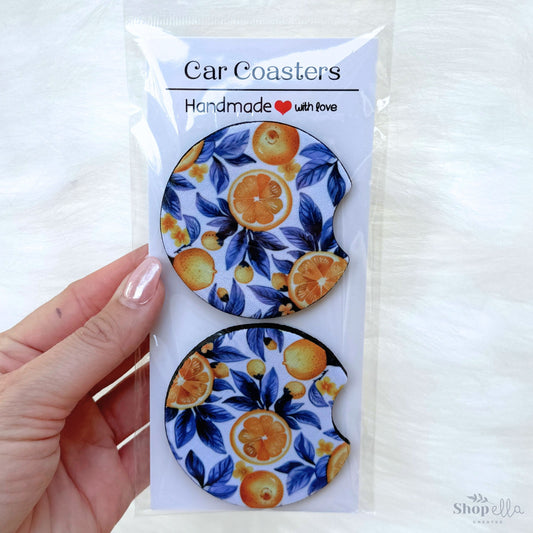 a package of car coasters with oranges on them with blue leaves. Mediterranean vibe