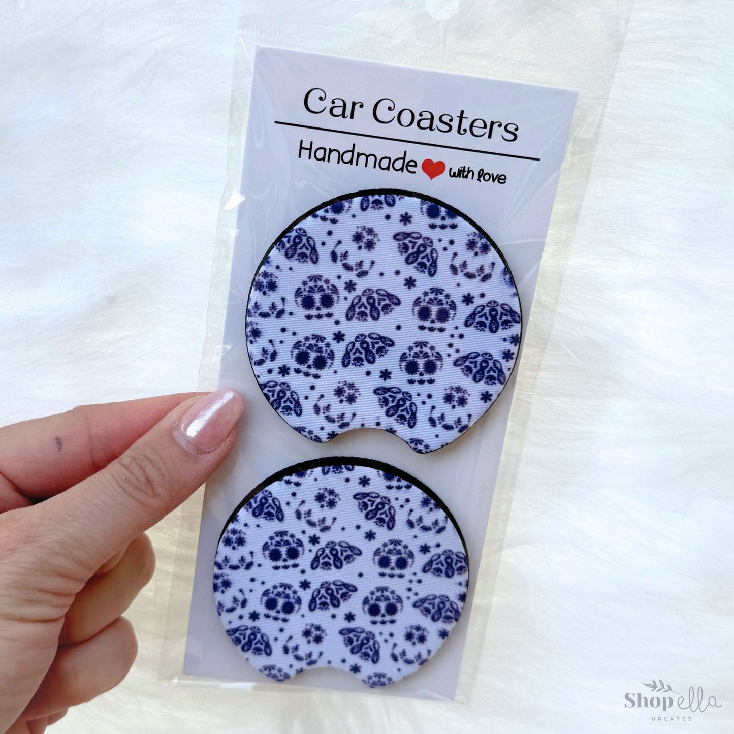 a package of 2 car coasters with blue and white day of the dead Dia de Muertos Talavera sugar skull ghosts